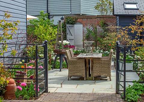 LITTLE_ORCHARDS_SURREY_DESIGNER_NIC_HOWARD_SPRING_APRIL_COURTYARD_TABLE_CHAIRS_CONTAINER_WITH_TULIPA