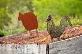 LITTLE ORCHARDS, SURREY, DESIGNER NIC HOWARD: LOG STORE, RUSTY METAL CUT OUT OF SHEEP, WIRE COCKERELL SCULPTURE, LIVING ROOF, SEDUMS