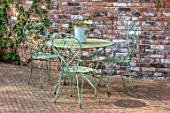 LITTLE ORCHARDS, SURREY, DESIGNER NIC HOWARD: METAL TABLE AND CHAIRS, SPRING, APRIL, PATIO, COURTYARD, WALLS