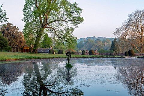 FORDE_ABBEY_SOMERSET_LAKE_AND_STATUE_IN_EARLY_MORNING_SUNSHINE_DAWN_APRIL_SPRING_WATER_POOL_REFLECTE