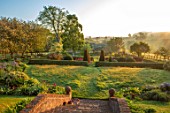 PETTIFERS, OXFORDSHIRE: THE PARTERRE IN SPRING, APRIL, EARLY MORNING, DAWN, STEPS, GRASS, LAWN, CLIPPED, YEW TOPIARY, ENGLISH, COUNTRY, GARDEN