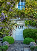 VILLAGE FARM HOUSE, GLOUCESTERSHIRE: FRONT DOOR, ROSA BANKSIAE LUTEA, WISTERIA FLORIBUNDA, CLIMBERS, HOUSE, WALLS, CLIMBING, SHRUBS, MAY, SPRING, COUNTRY, GARDEN