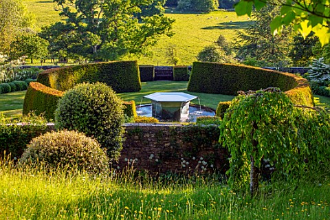 FONTHILL_HOUSE_GARDENS_WATER_GARDEN_ON_SLOPE_WILLIAM_PYE_WATER_FEATURE_YEW_HEDGES_HEDGING_SPRING_MAY