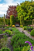 YORK GATE, YORKSHIRE: HERB GARDEN, JUNE, SUMMER, CLIPPED TOPIARY HEDGES, COLUMNS, WOODEN BENCH, SEAT, WOVEN WILLOW HOOD