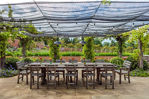 ALDERWOOD_HOUSE_KENT_TERRACE_PATIO_WOODEN_TABLE_CHAIRS_NETTING_GLASS_JARS_ON_TABLE_WITH_GALLARDIA_BU