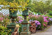 LARCH COTTAGE NURSERIES, CUMBRIA: URNS, CONTAINERS, BORDER OF PHLOX, BORDERS, ORNAMENTS, FORMAL, PINK FLOWERS, SUMMER, GREENHOUSE