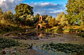 LARCH COTTAGE NURSERIES, CUMBRIA: POOL, POND, WATER, WATERLILIES, CHAPEL BUILT IN 2014 BY PETER STOTT, STORMY WEATHER, EVENING LIGHT