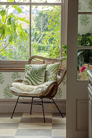 ASHBROOK_HOUSE_NORTHAMPTONSHIRE_VIEW_THROUGH_TO_CHAIR_WITH_FERN_CUSHION_IN_BOOT_ROOM_CONSERVATORY