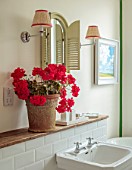 ASHBROOK HOUSE, NORTHAMPTONSHIRE: BATHROOM WITH PINK GERANIUMS IN TERRACOTTA CONTAINER