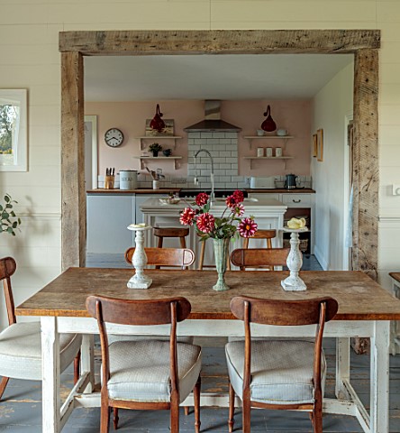 ASHBROOK_HOUSE_NORTHAMPTONSHIRE_TABLE_WITH_FLOWERS_VIEW_THROUGH_TO_KITCHEN_DINING_ROOM