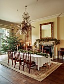 MARBURY HALL, SHROPSHIRE: DESIGNER SOFIE PATON-SMITH - DINING ROOM, CHRISTMAS TREE, FIREPLACE GARLAND OF HOPS, TABLE, CHAIRS, DECEMBER
