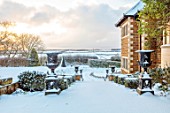 REDHILL LODGE, RUTLAND: DESIGNERS RICHARD AND SUSAN MOFFITT - GARDEN, SNOW, JANUARY, WINTER, HOUSE, CONTAINERS, STEPS, LANDSCAPE
