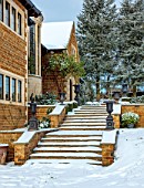 REDHILL LODGE, RUTLAND: DESIGNERS RICHARD AND SUSAN MOFFITT - TREES, STEPS, HOUSE, METAL CONTAINERS, WINTER, SNOW, JANUARY