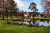 HEVER CASTLE & GARDENS, KENT: DAFFODILS, NARCISSUS, BESIDE LAKE, POND, REFLECTIONS, MARCH, REFLECTED, TREES, BUILDINGS, SPRING, BULBS