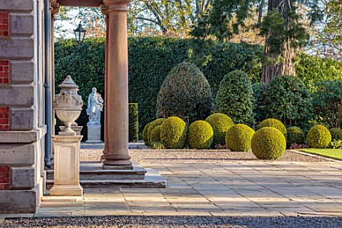 MORTON_HALL_WORCESTERSHIRE_FRONT_TERRACE_OF_HALL_SPRING_APRIL_STONE_URNS_STATUE_TERRACE_CLIPPED_TOPI