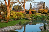 LOWER BOWDEN MANOR, BERKSHIRE: SPRING, APRIL, SUNRISE, MORNING, ENGLISH, COUNTRY, GARDEN, POND, POOL, WOODEN BENCH, SEAT